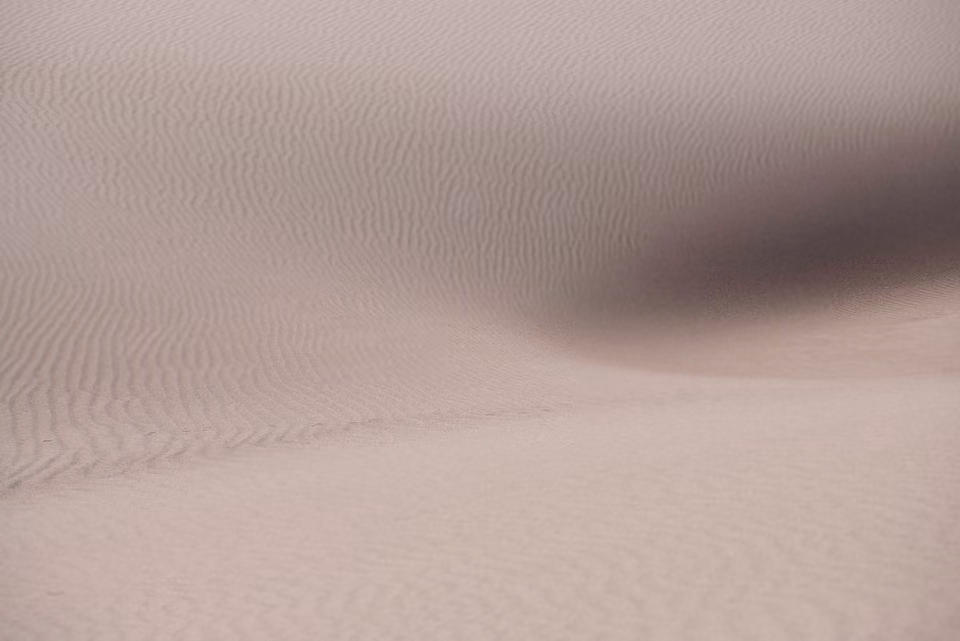a person walking through a sand dune
