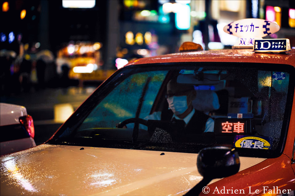 a taxi cab with a man in a face mask driving
