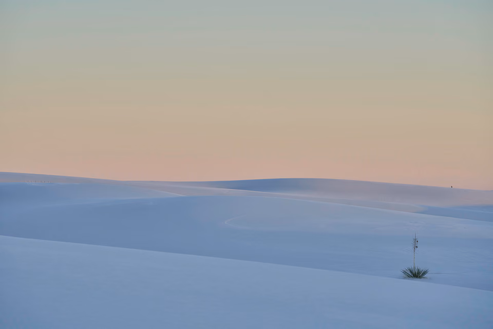 a lone person standing on a snowy hill
