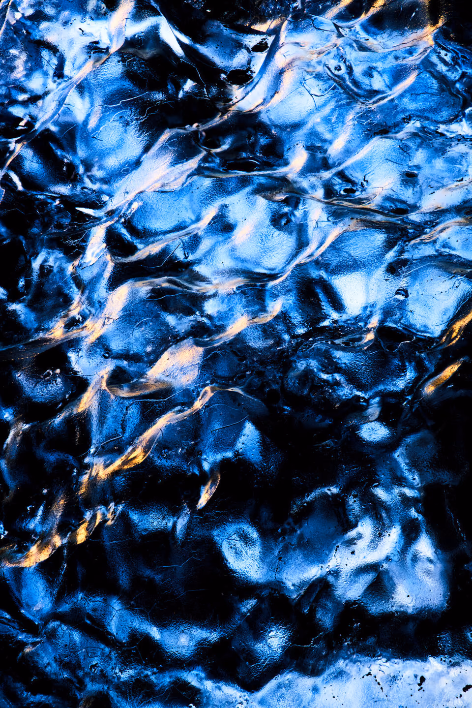 a close up of water with blue and yellow lights

