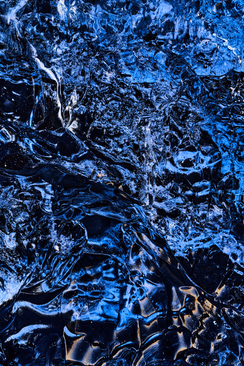 a close up of blue water with some ice
