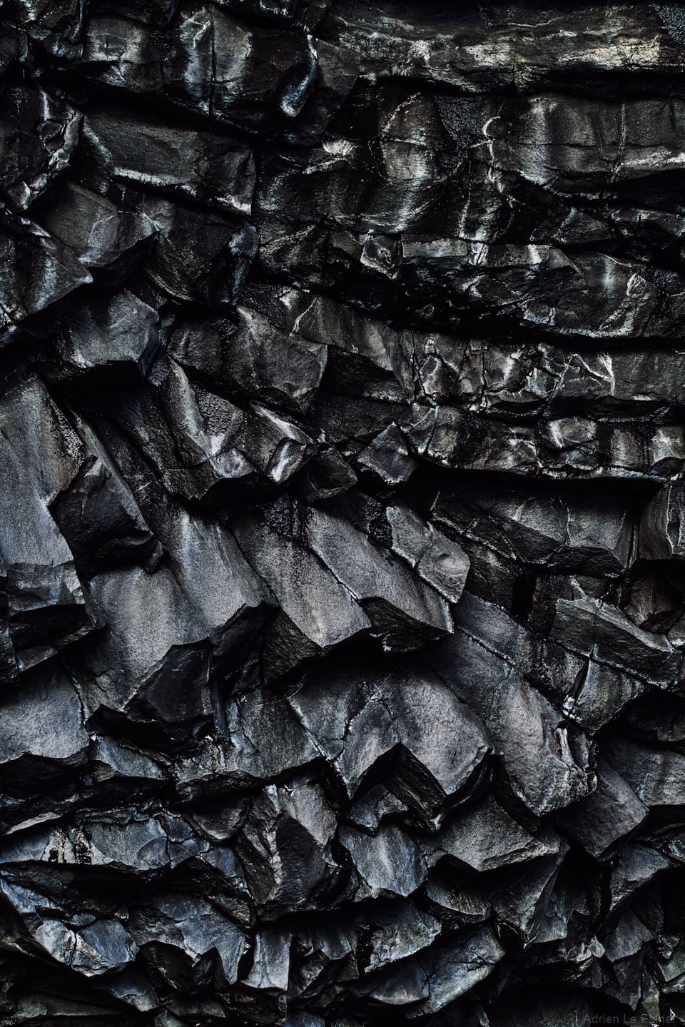 a black and white photo of a black rock wall
