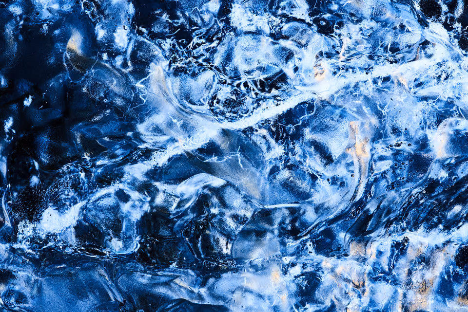 a close up of water with blue and white ice
