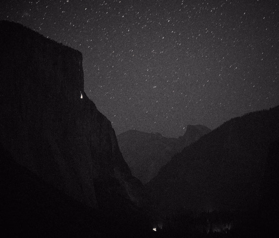 black and white photo of a mountain with stars
