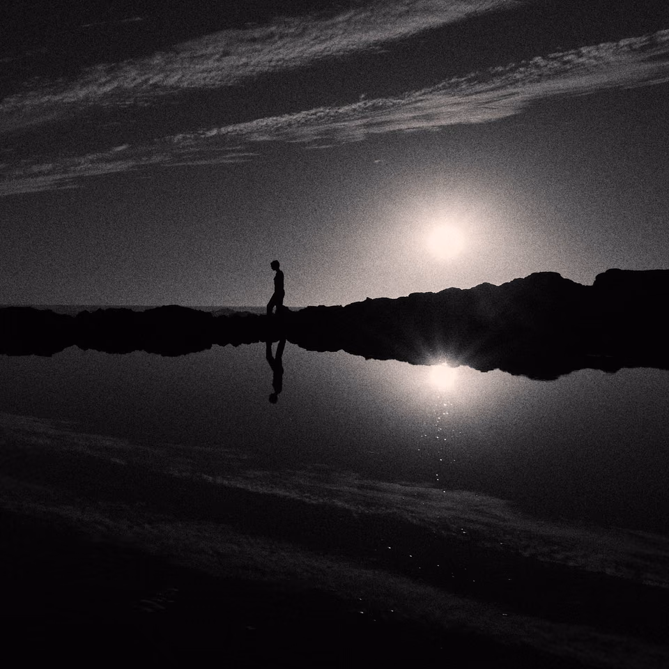 a person walking on the beach at night
