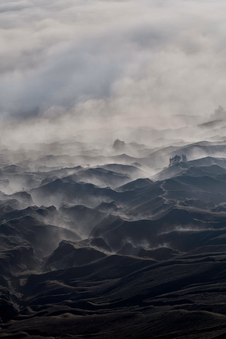 a foggy landscape with mountains and hills
