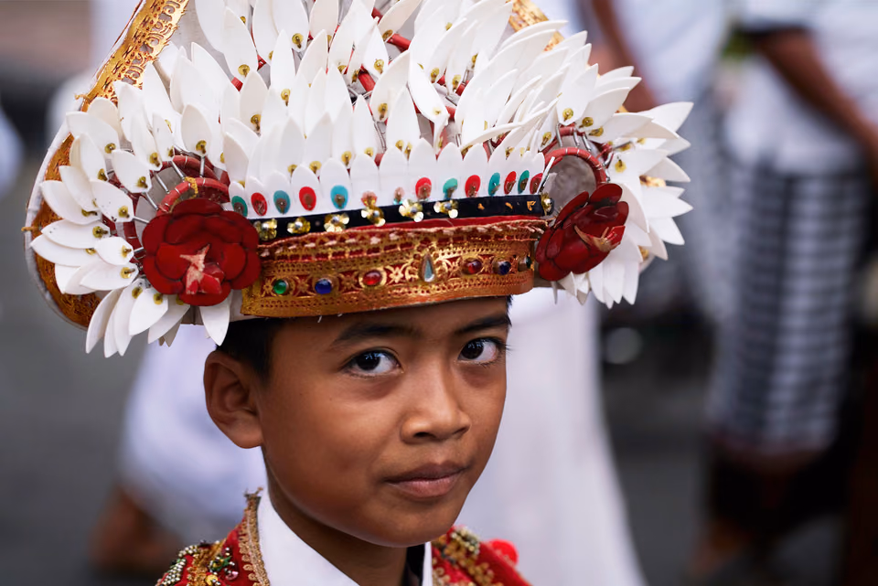 a young boy in a traditional costume with a feather headdress
