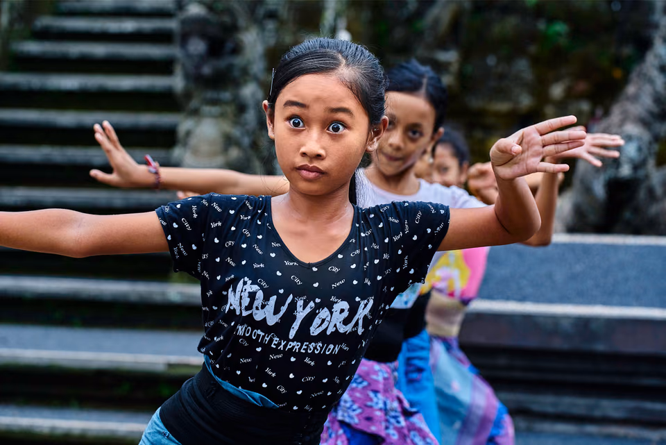 a young girl is dancing in front of some steps
