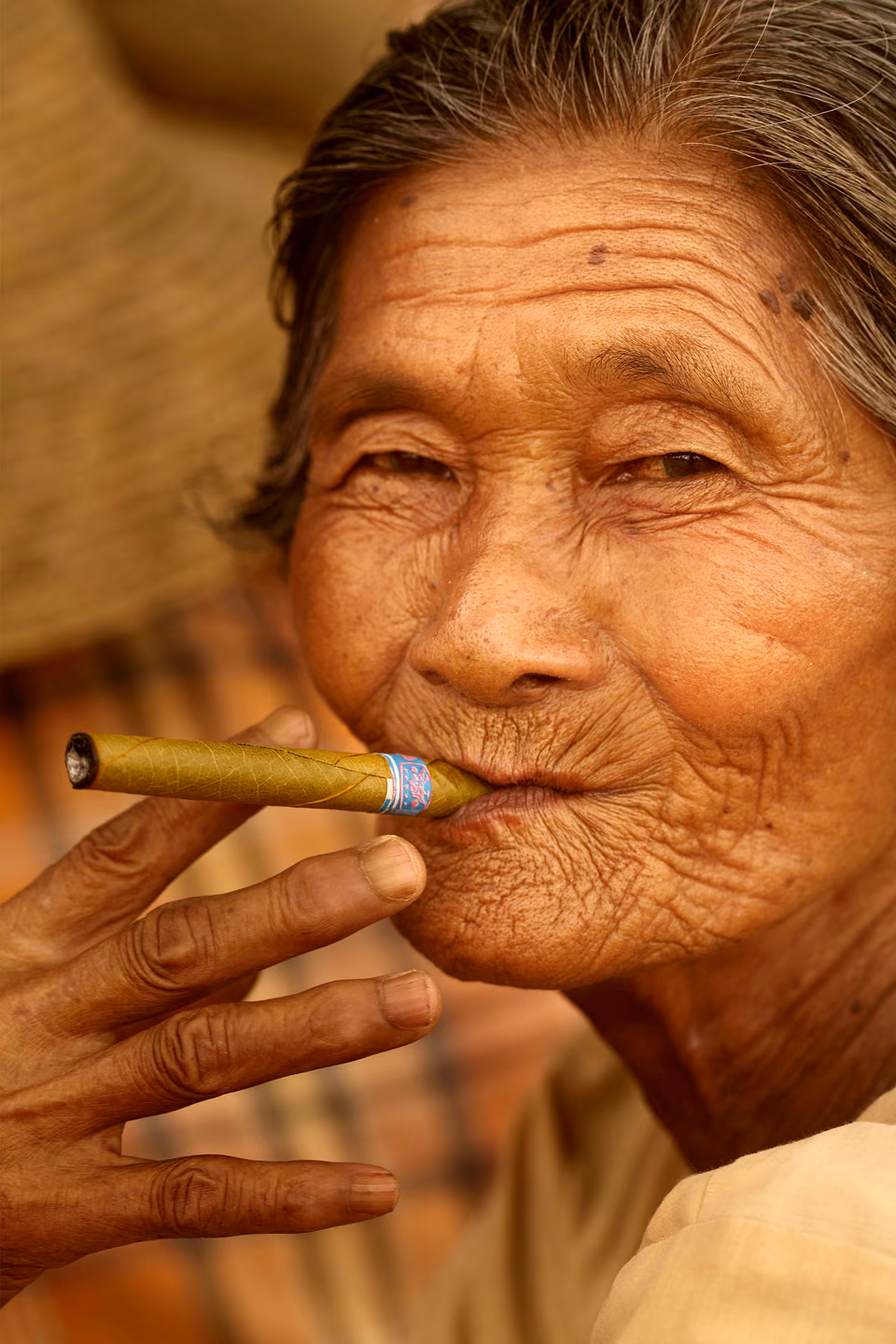 an old woman smoking a cigar in her hand
