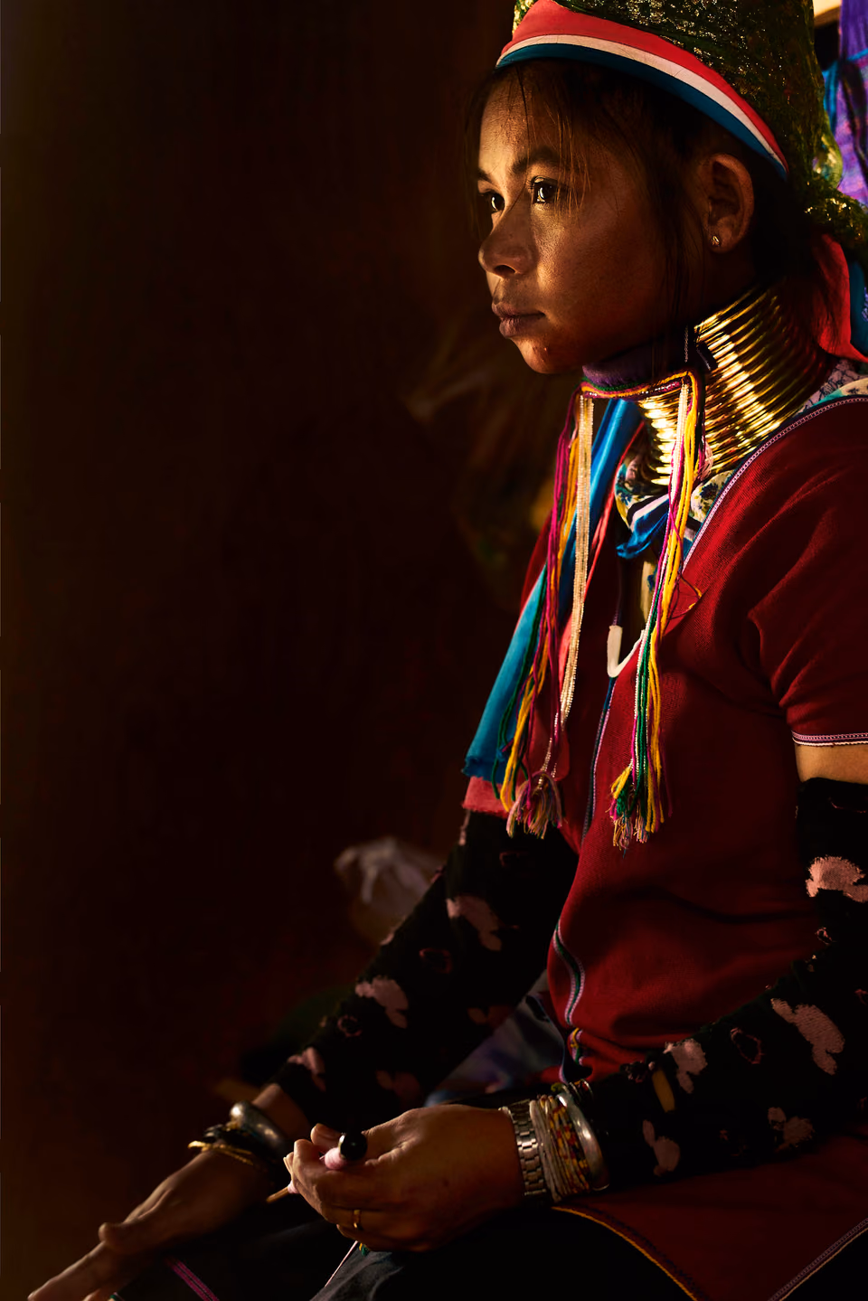 PORTRAITS OF THE WORLD — a woman in traditional clothing sitting on a chair