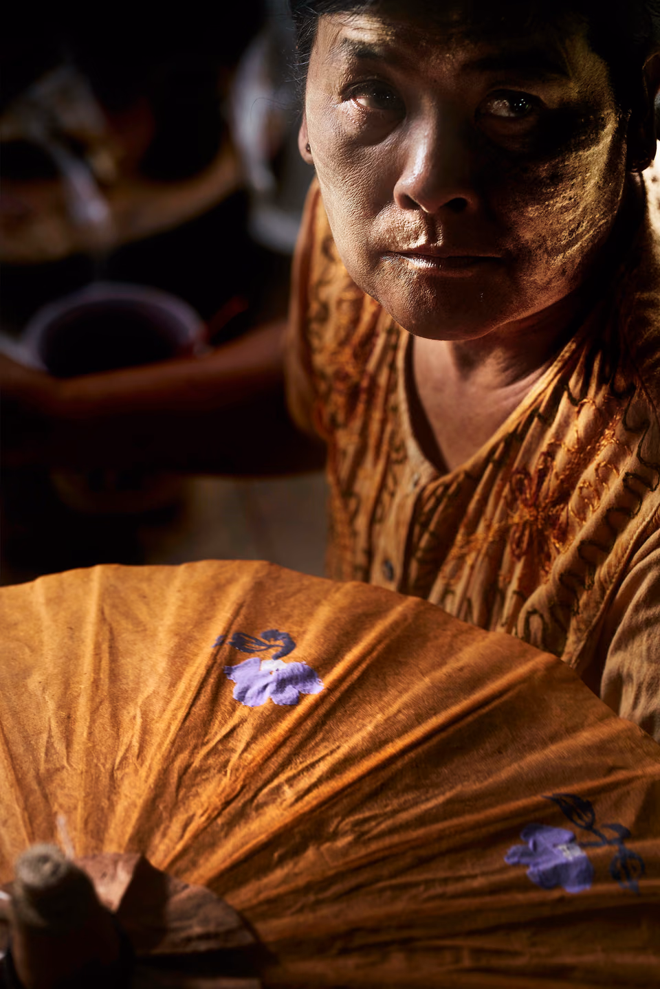 a woman holding a yellow umbrella with purple writing on it

