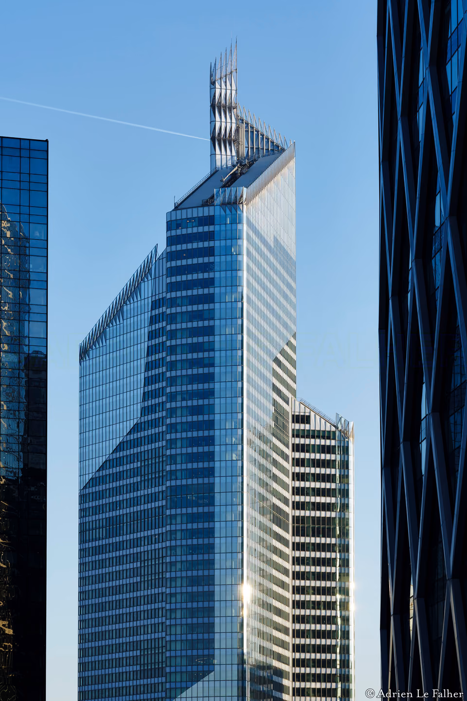 a large building with many windows and a plane flying by
