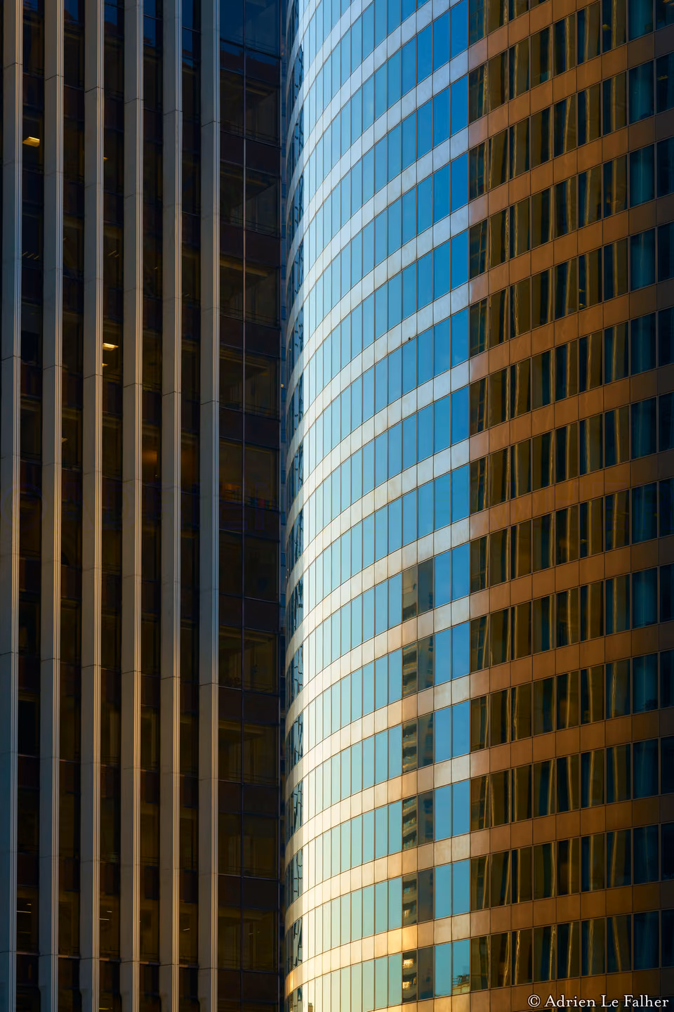 two buildings are reflected in the glass of each other
