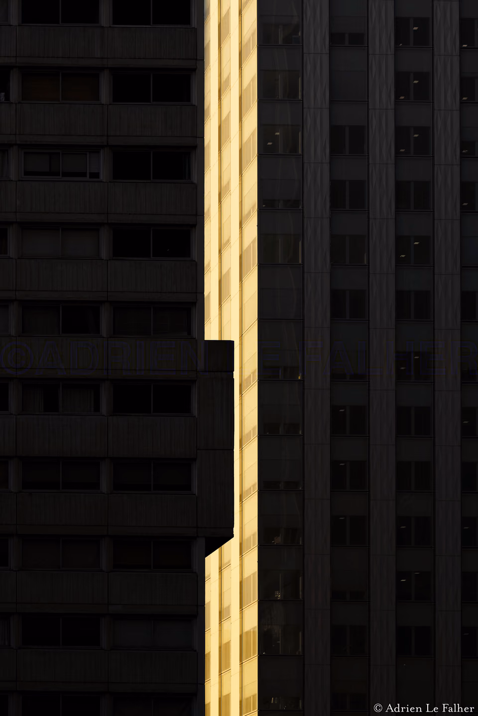 a tall building with a yellow light shining on it
