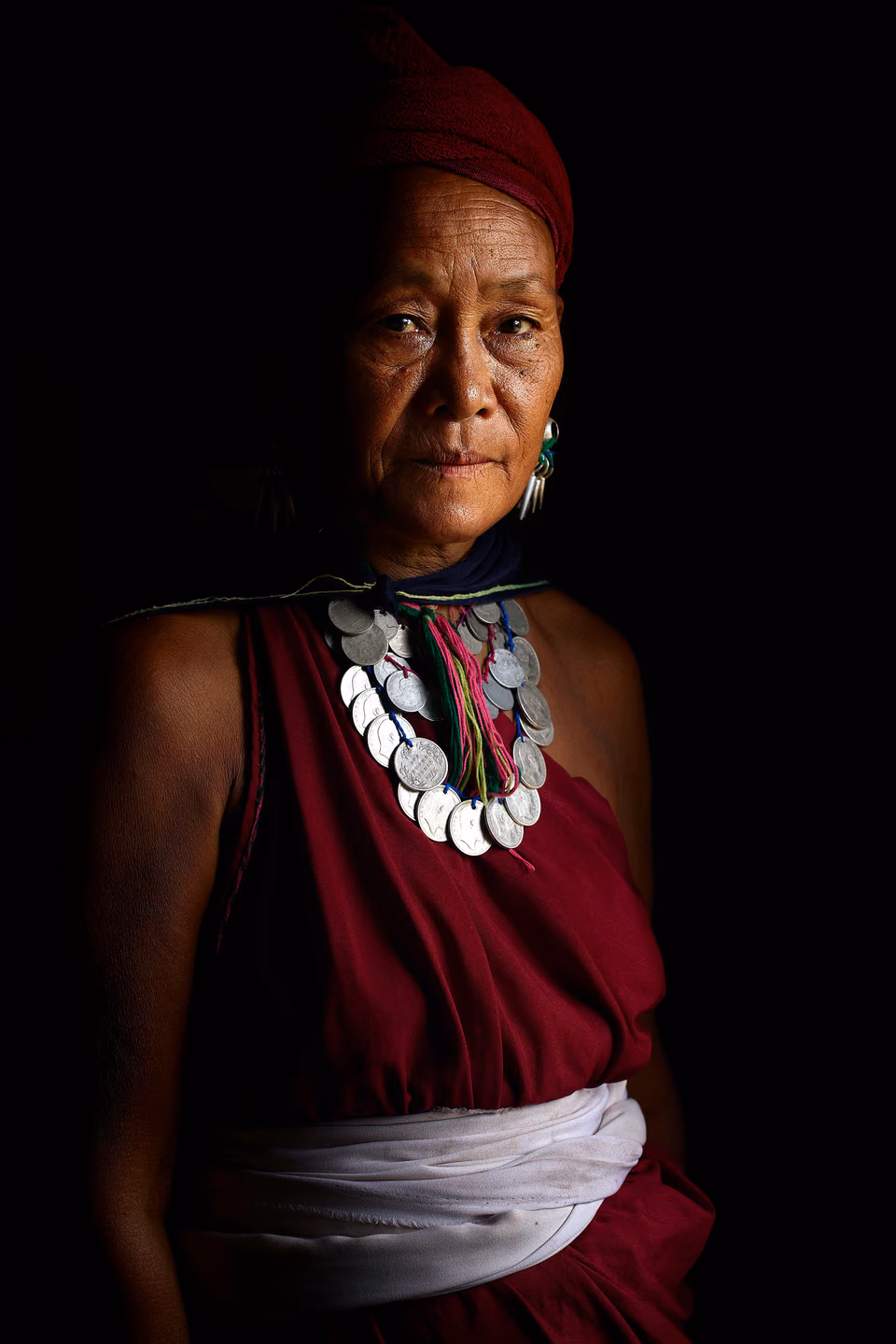 a woman in a red dress and necklace
