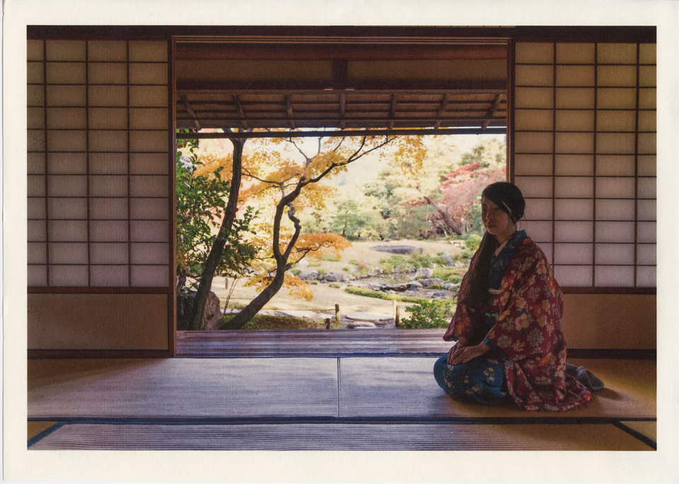 a woman in a kimono sitting on the floor
