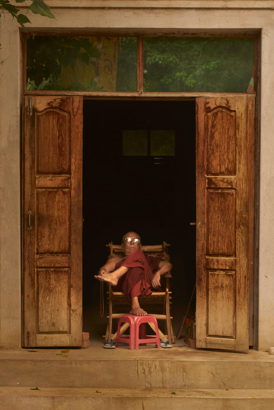 a man sitting in a chair in front of a door
