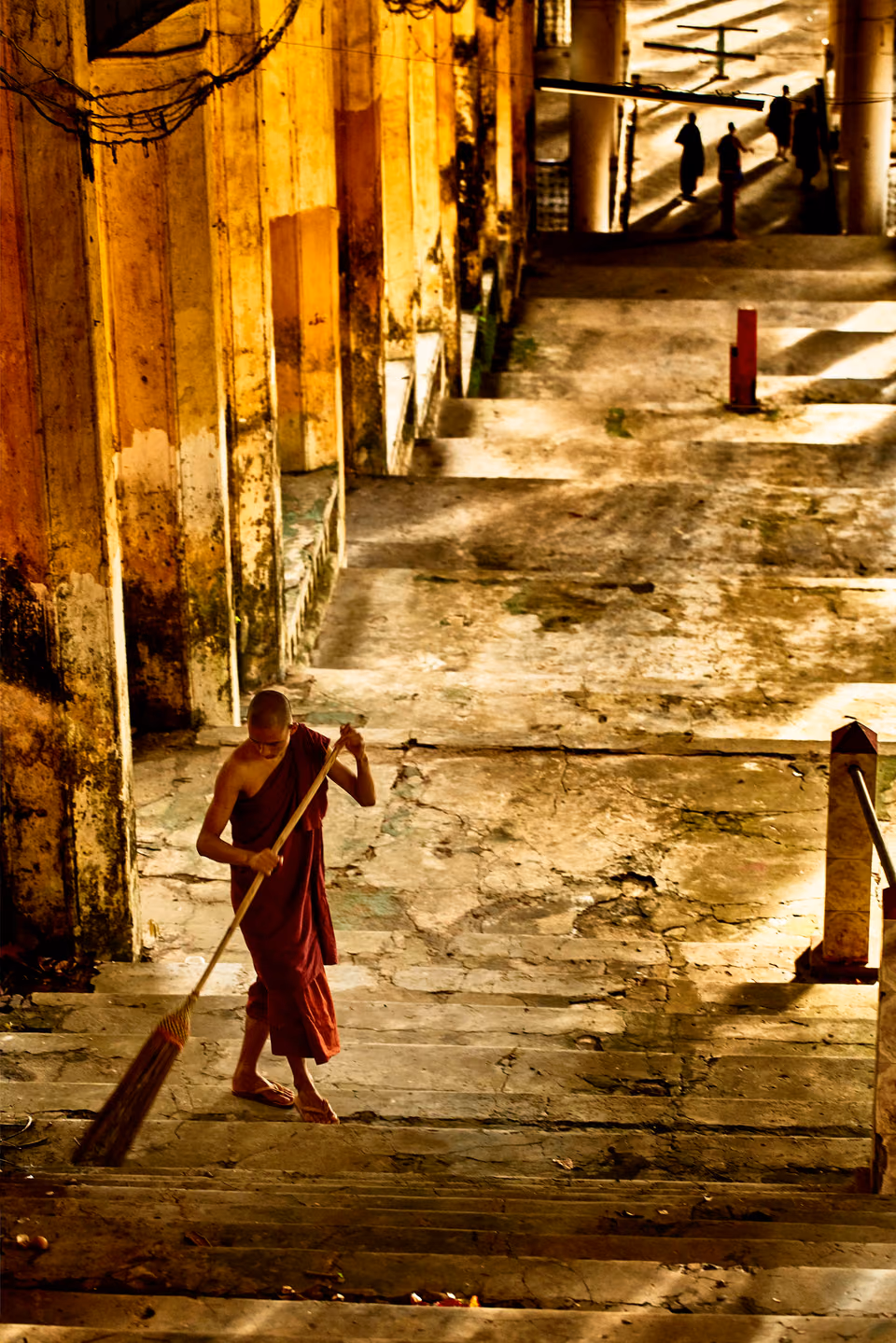 a monk is sweeping the floor
