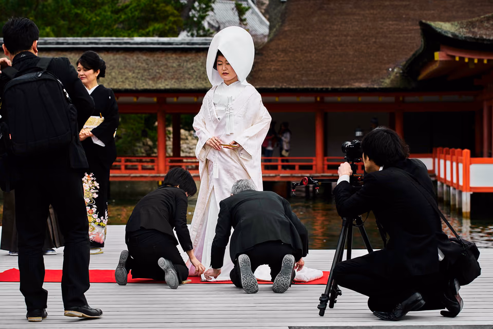 a woman in a wedding dress is being photographed by a man
