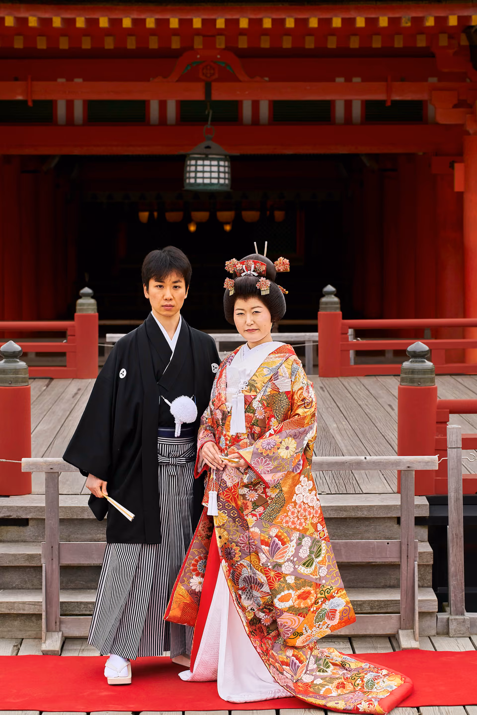 a couple of people standing on a red carpet
