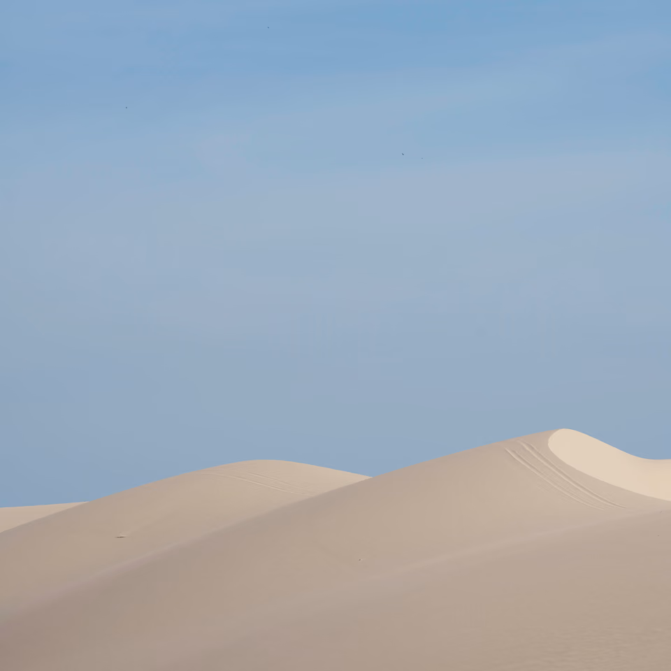 a person riding a skateboard on a sandy beach
