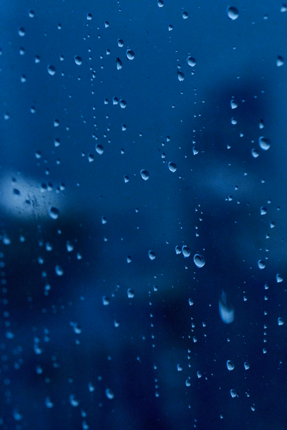 raindrops on a window glass with a city in the background
