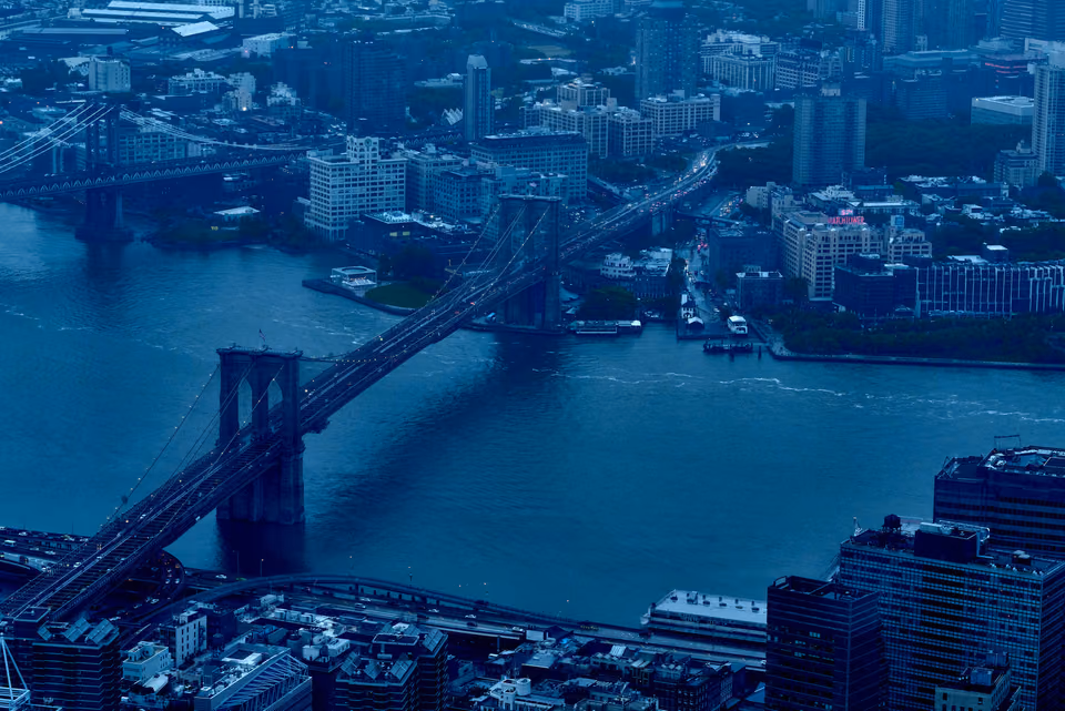 a city skyline with a bridge and a river
