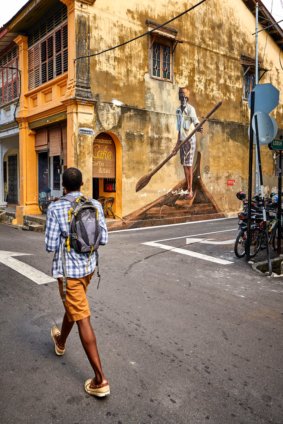 a man walking down the street with a skateboard
