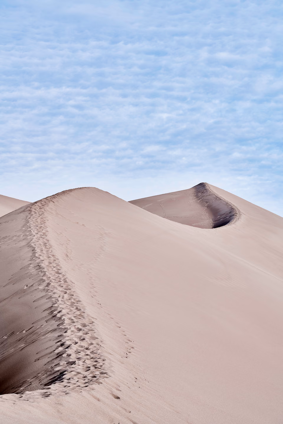 a person walking on a sand dune
