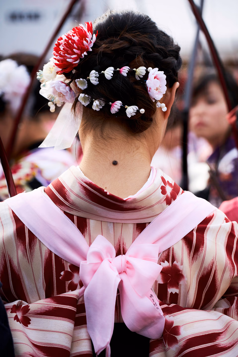 a woman with a flower on her head and a bow on her back
