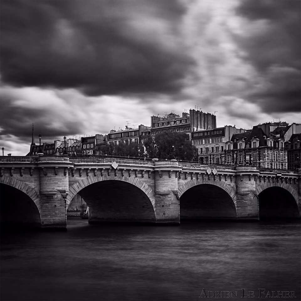 a black and white photo of a bridge over a river
